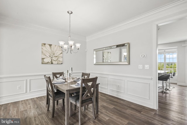 dining space featuring a wainscoted wall, dark wood-style floors, a notable chandelier, ornamental molding, and a decorative wall