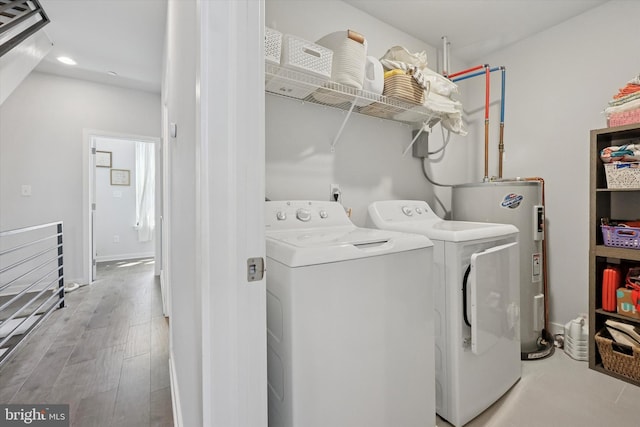 clothes washing area featuring water heater, laundry area, recessed lighting, and washing machine and clothes dryer