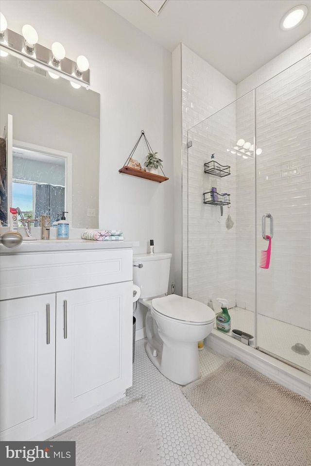 bathroom with vanity, a stall shower, and toilet