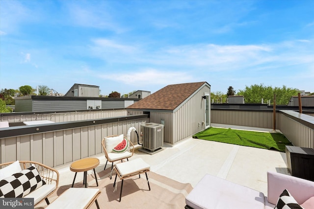 view of patio / terrace with central air condition unit, an outdoor structure, a fenced backyard, and a shed