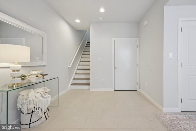 tiled foyer with recessed lighting, baseboards, and stairway