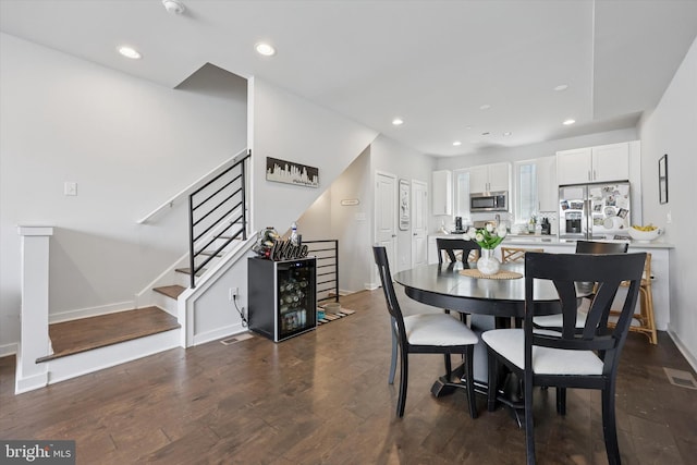 dining space featuring recessed lighting, baseboards, dark wood finished floors, and stairs