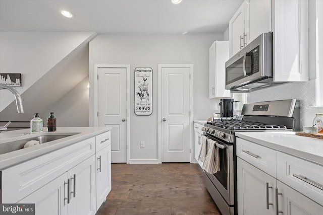 kitchen featuring a sink, light countertops, stainless steel appliances, recessed lighting, and white cabinetry