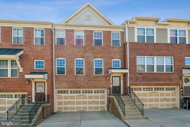 multi unit property featuring brick siding, driveway, and a garage