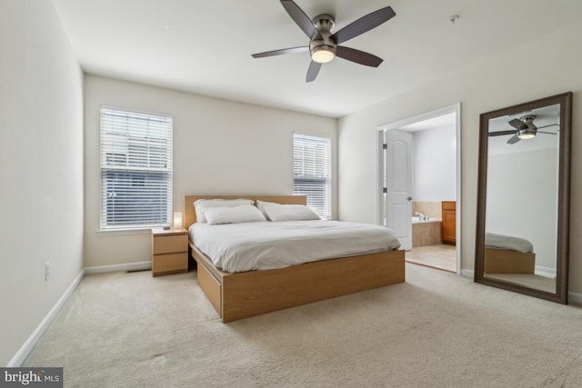 bedroom featuring baseboards, light colored carpet, multiple windows, and ensuite bathroom