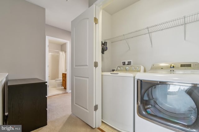 laundry area with laundry area, light colored carpet, and washer and dryer