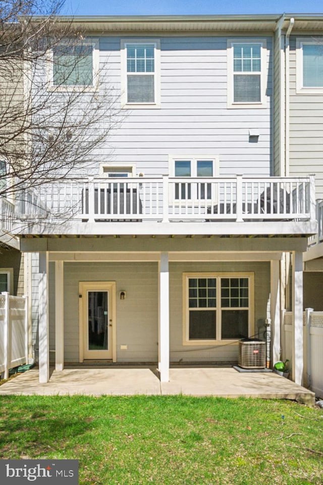 rear view of house with a yard, a patio, central AC, and fence