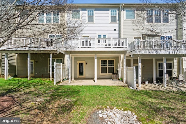 back of property featuring a lawn, a patio area, and a wooden deck