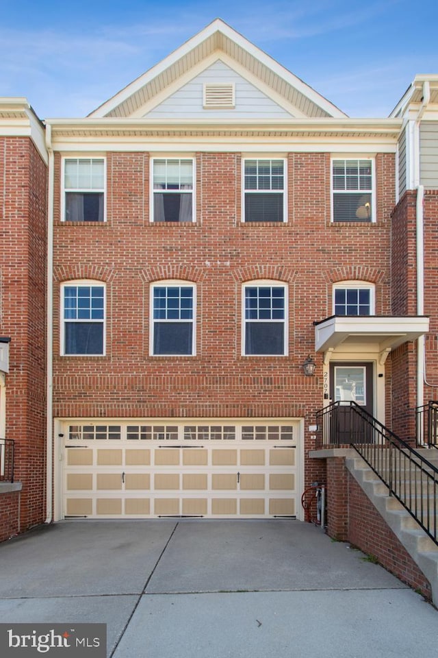 view of property featuring an attached garage, brick siding, and concrete driveway