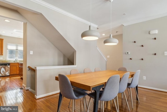 dining area with light wood-style floors, recessed lighting, baseboards, and crown molding
