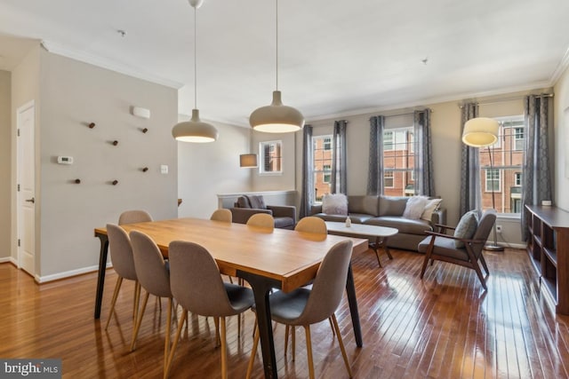dining room featuring crown molding, baseboards, and hardwood / wood-style floors
