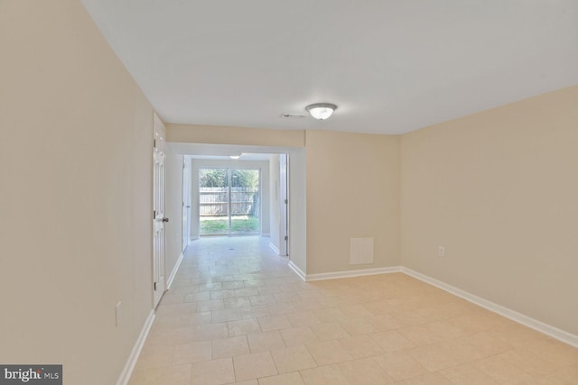 hall with baseboards, light tile patterned flooring, and visible vents