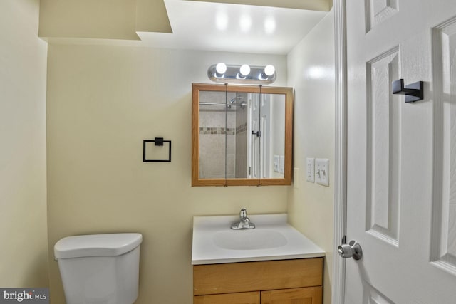 bathroom with toilet, walk in shower, and vanity