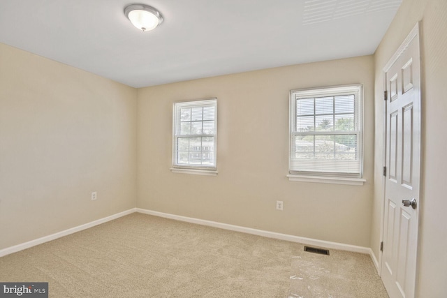 unfurnished room featuring carpet floors, baseboards, and a wealth of natural light