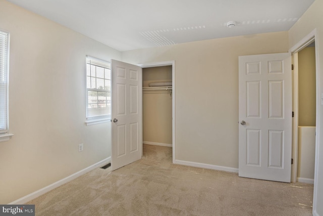 unfurnished bedroom featuring carpet floors, baseboards, visible vents, and a closet