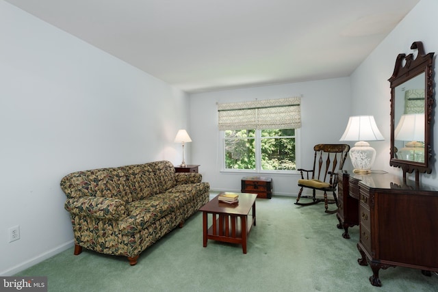 living area featuring light colored carpet and baseboards