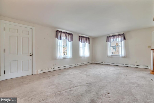 unfurnished living room with a baseboard heating unit and carpet