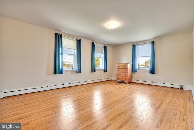 unfurnished room featuring wood-type flooring and baseboard heating