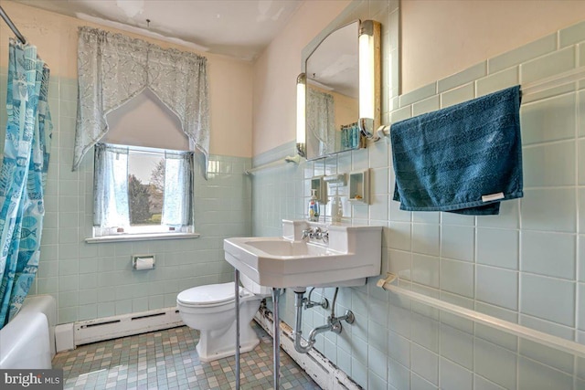 full bath featuring toilet, tile walls, a wealth of natural light, and a baseboard radiator