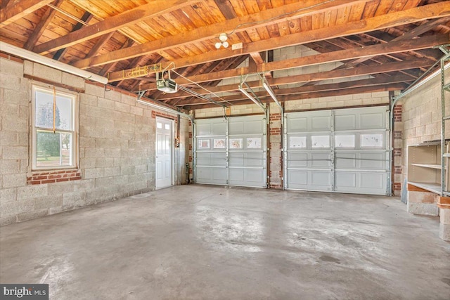 garage with concrete block wall and a garage door opener