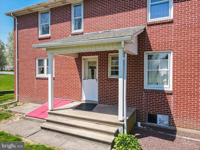 view of exterior entry featuring brick siding