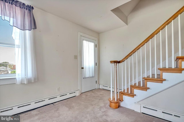 entrance foyer featuring a baseboard radiator, a wealth of natural light, and carpet flooring