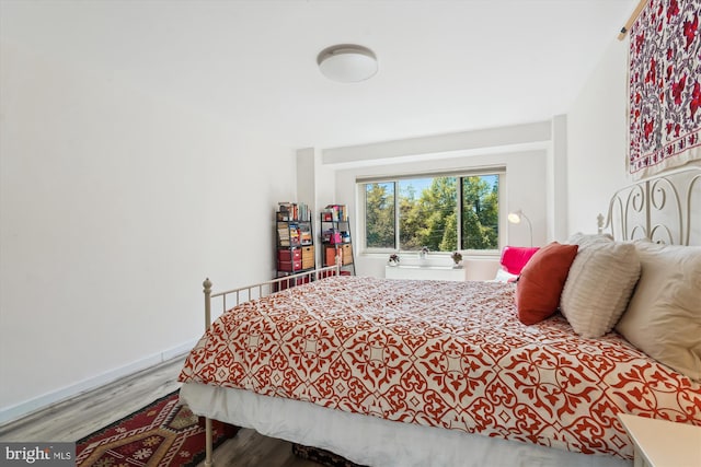 bedroom with baseboards and wood finished floors