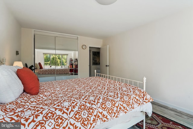 bedroom featuring baseboards, a closet, and wood finished floors