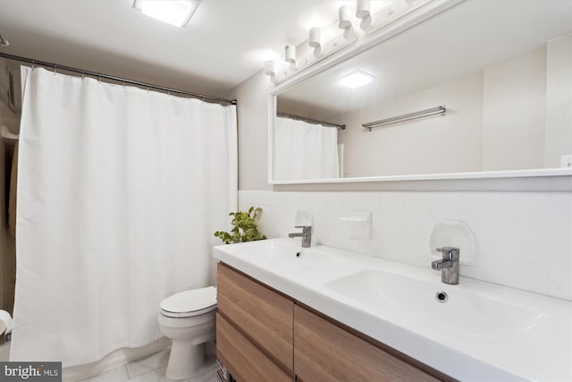 full bathroom featuring double vanity, a sink, curtained shower, and toilet