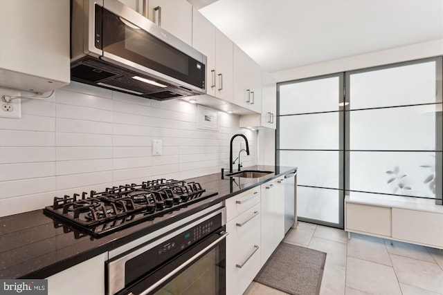 kitchen featuring a sink, white cabinetry, appliances with stainless steel finishes, and tasteful backsplash
