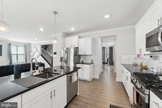 kitchen featuring a sink, decorative backsplash, appliances with stainless steel finishes, and ornamental molding