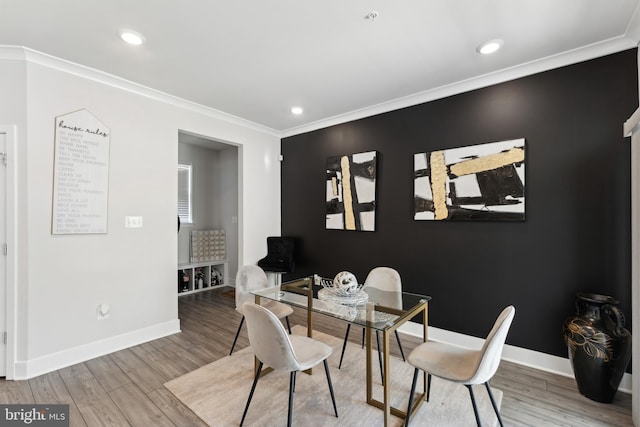 dining room featuring baseboards, ornamental molding, recessed lighting, and wood finished floors
