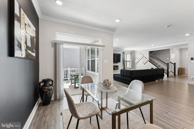 dining space with recessed lighting, ornamental molding, light wood-style flooring, and stairway