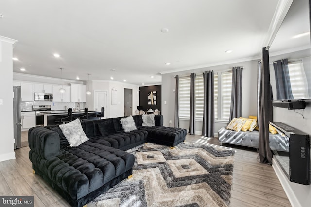 living area with recessed lighting, ornamental molding, and light wood-style floors