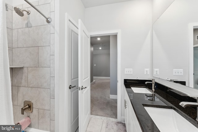 full bath featuring a sink, baseboards, shower / bathtub combination with curtain, and double vanity