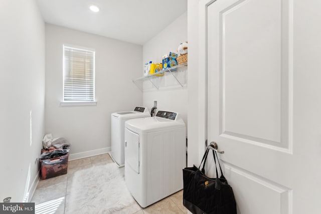 washroom with laundry area, baseboards, light tile patterned floors, and separate washer and dryer