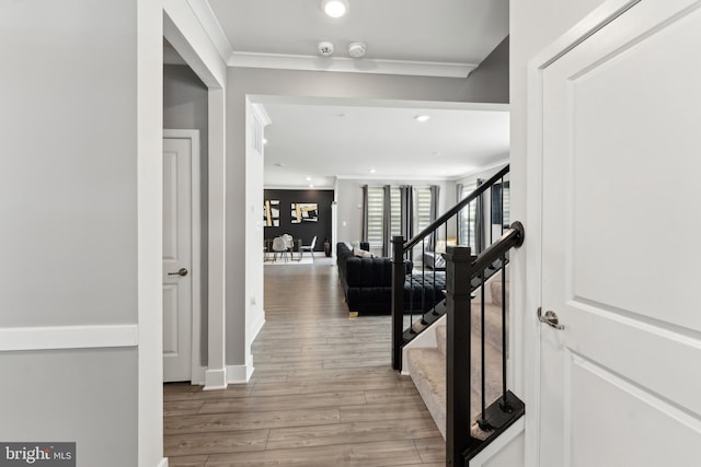 corridor with stairway, ornamental molding, recessed lighting, and wood finished floors
