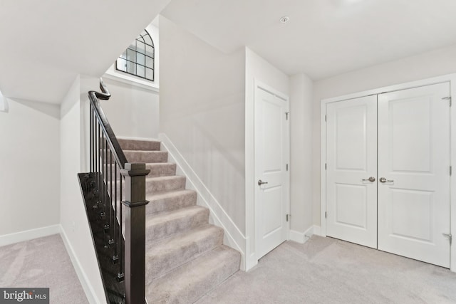 staircase featuring carpet floors and baseboards