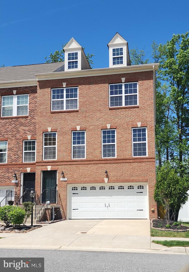 townhome / multi-family property featuring concrete driveway, brick siding, and an attached garage
