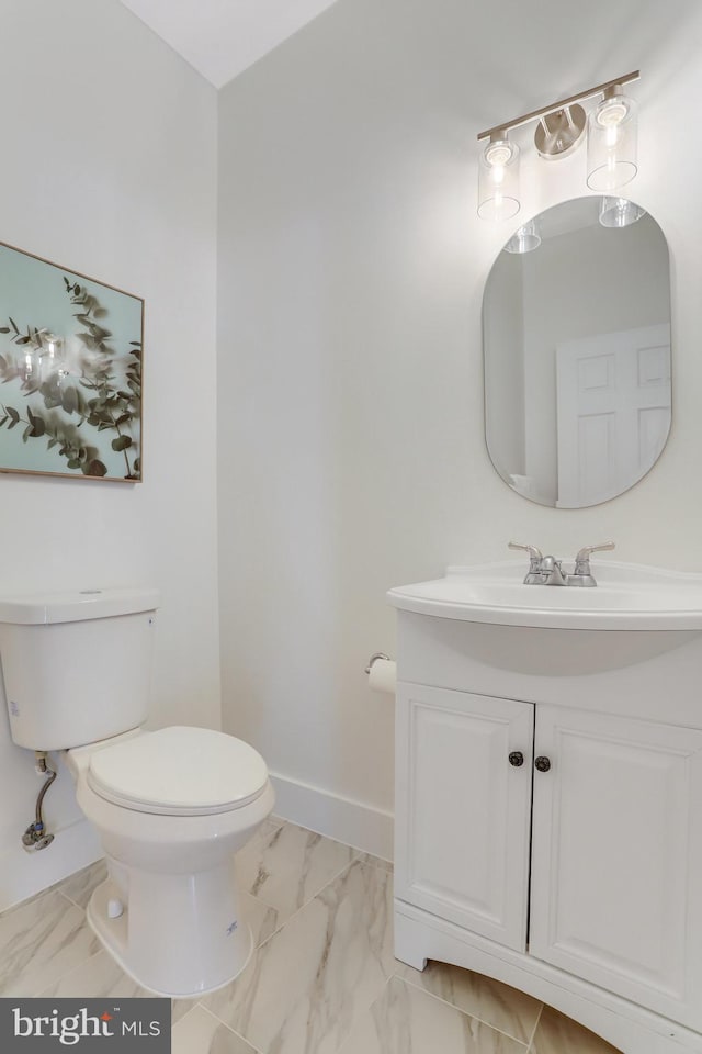 bathroom with vanity, marble finish floor, baseboards, and toilet
