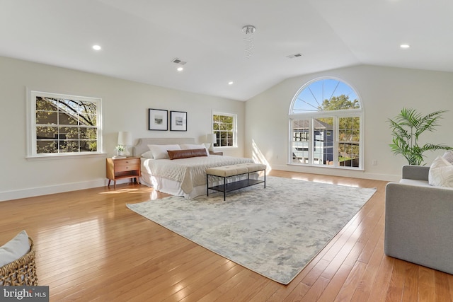 bedroom featuring baseboards, vaulted ceiling, light wood-type flooring, and visible vents