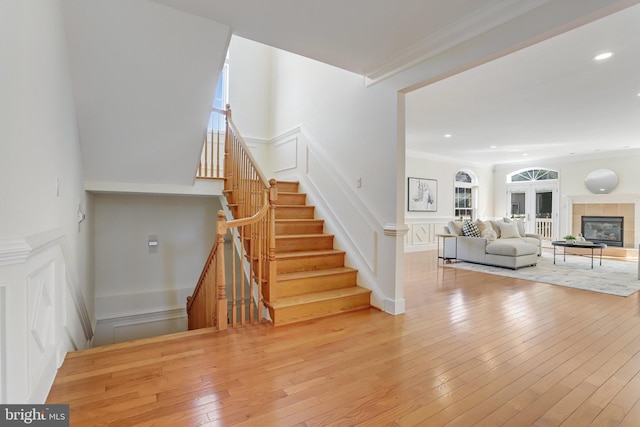 staircase featuring a decorative wall, a healthy amount of sunlight, and hardwood / wood-style floors