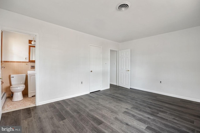 24 Elk Rd, Mullica Hill, NJ 08062 - unfurnished bedroom featuring visible vents, tile walls, baseboards, dark wood-style floors, and connected bathroom