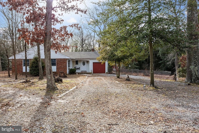 24 Elk Rd, Mullica Hill, NJ 08062 - ranch-style house featuring a chimney, dirt driveway, brick siding, fence, and an attached garage