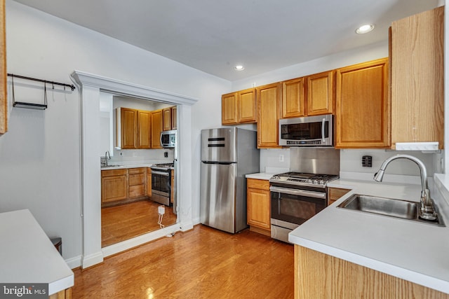 8716 Salinas Ct, Odenton, MD 21113 - kitchen with appliances with stainless steel finishes, a sink, light wood-style floors, recessed lighting, and light countertops
