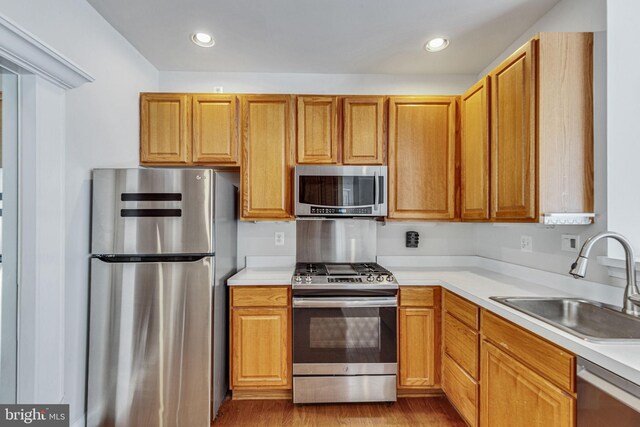 8716 Salinas Ct, Odenton, MD 21113 - kitchen with appliances with stainless steel finishes, a sink, wood finished floors, light countertops, and recessed lighting