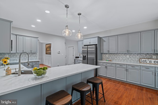 13647 Van Doren Rd, Manassas, VA 20112 - kitchen featuring gray cabinetry, stainless steel fridge with ice dispenser, a breakfast bar, backsplash, and recessed lighting