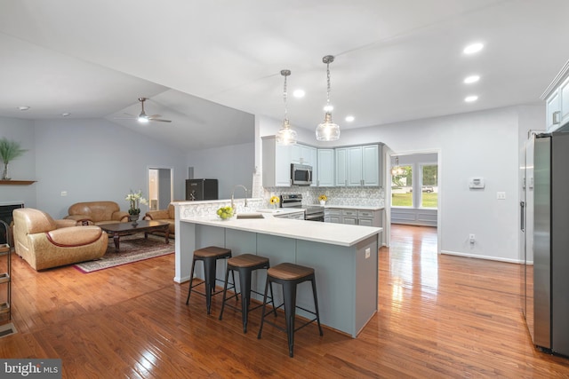 13647 Van Doren Rd, Manassas, VA 20112 - kitchen featuring appliances with stainless steel finishes, a peninsula, a breakfast bar area, wood finished floors, and a ceiling fan