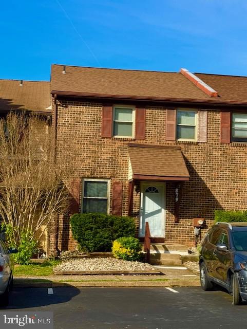 multi unit property featuring brick siding and roof with shingles