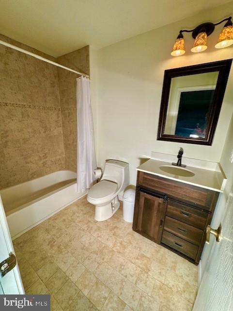 full bathroom with vanity, shower / bathtub combination with curtain, and toilet